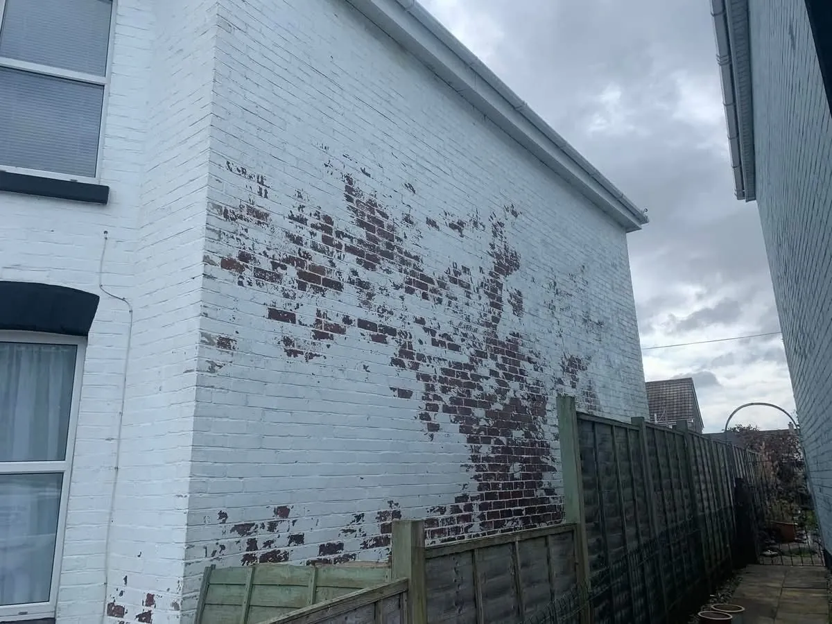 Peeling paint on a brick wall before redecoration in Totnes